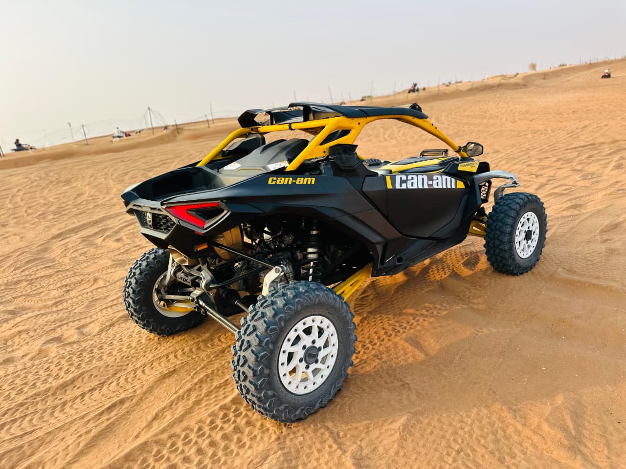 Black and yellow Can-Am dune buggy on Dubai desert sand dunes